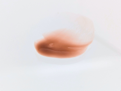 Swatch of Covet Beauty’s Chocolate Cookie lip gloss — a smooth medium brown gloss with a creamy finish on a white background.