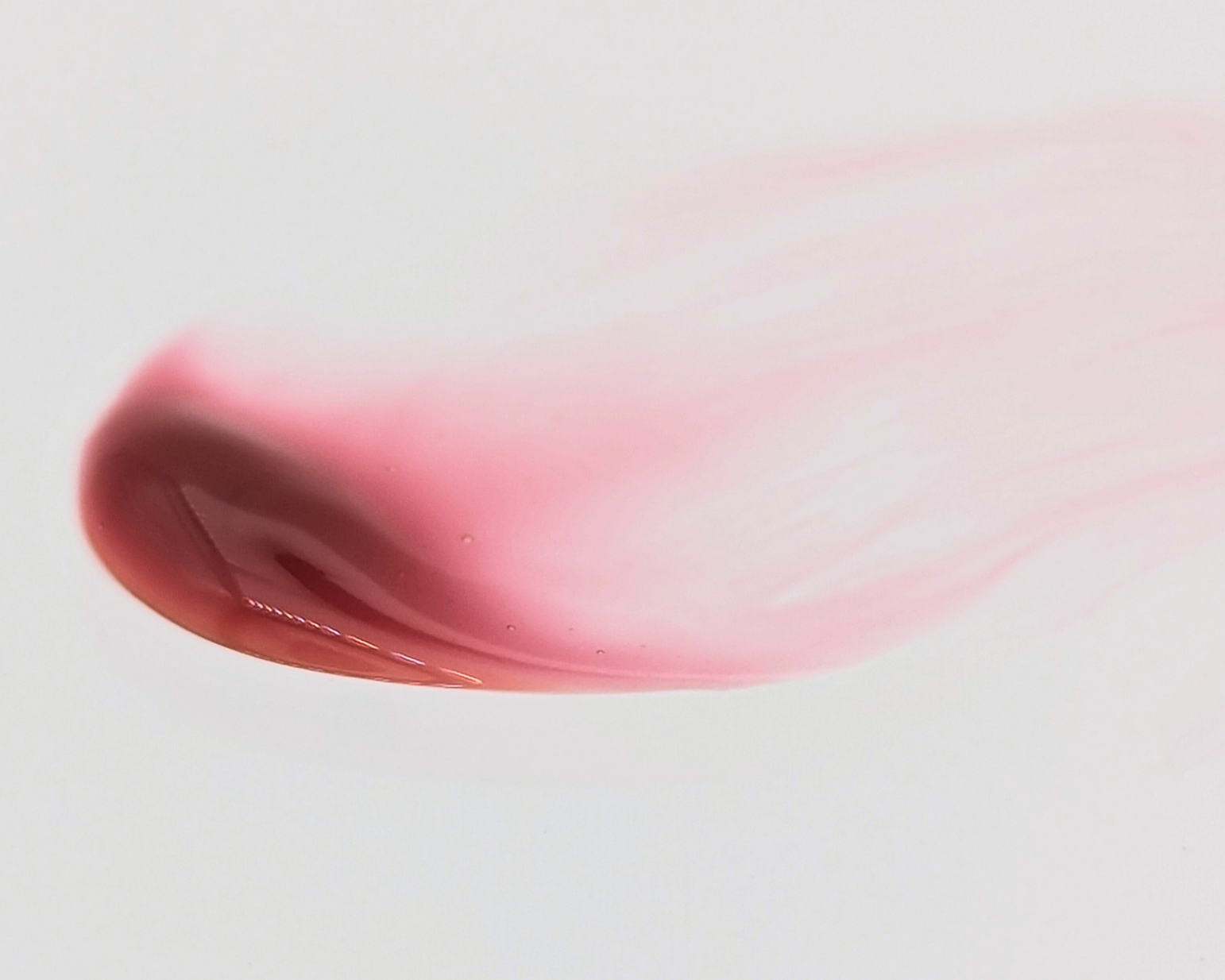 Swatch of Covet Beauty’s Hazelnut Cream lip gloss — a warm medium brown gloss with soft red undertones and a creamy finish on a white background