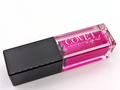 Covet Beauty’s Jupiter lip gloss — a bold fuchsia gloss in a clear rectangular tube with black cap. Transforms into a vivid cool pink based on skin pH and heat.
