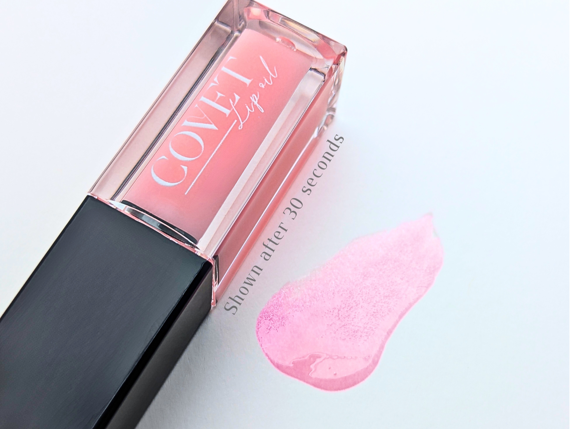 Covet Beauty Mercury lip gloss — sheer cool-toned pink gloss with a glossy finish, shown in a clear square tube and swatched on a white background 30 seconds of activation.