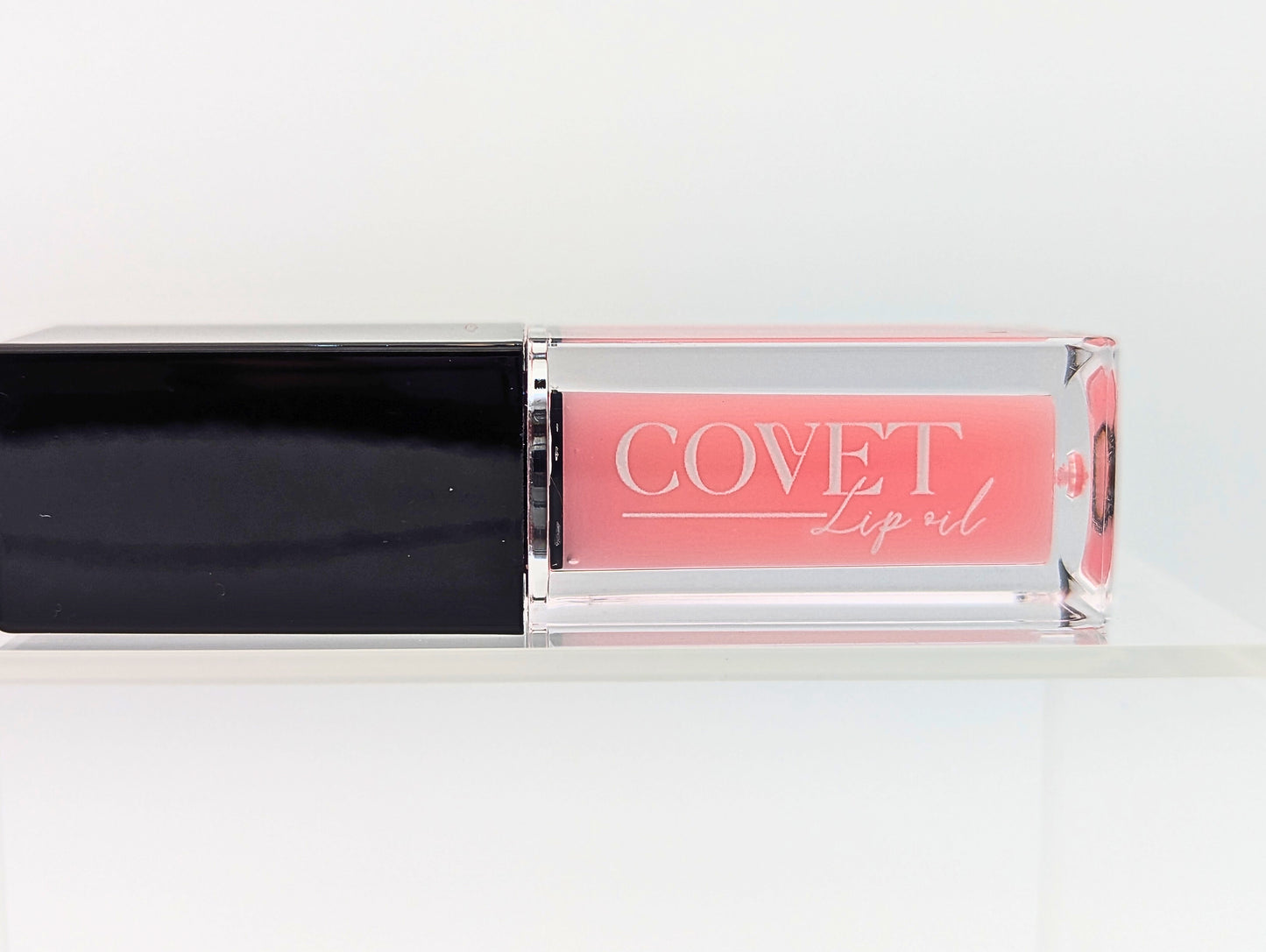 Covet Beauty’s Mercury lip gloss — a blush pink gloss in a clear rectangular tube with black cap. Transforms into a medium cool-toned pink based on skin pH and heat