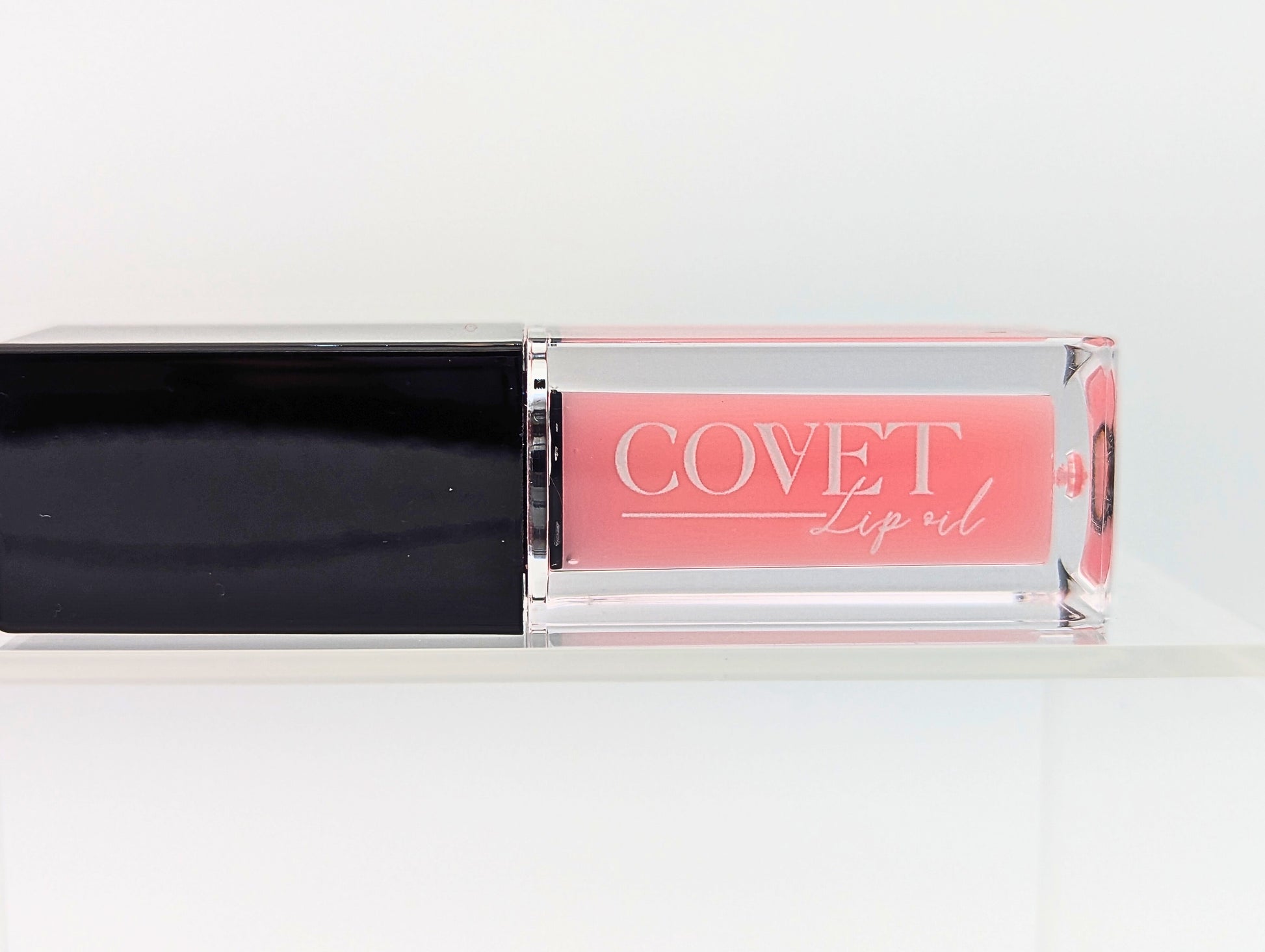 Covet Beauty’s Mercury lip gloss — a blush pink gloss in a clear rectangular tube with black cap. Transforms into a medium cool-toned pink based on skin pH and heat