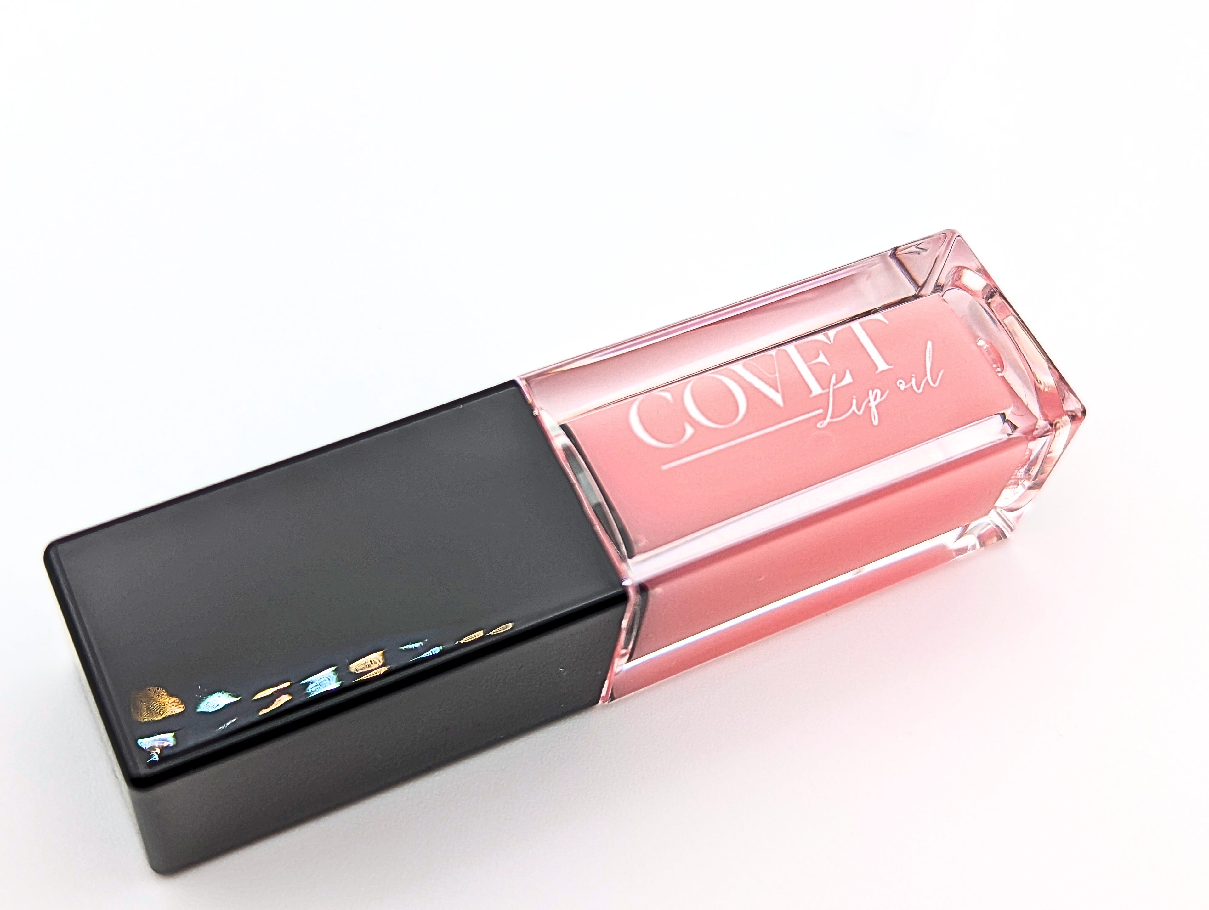Covet Beauty’s Mercury lip gloss — a blush pink gloss in a clear rectangular tube with black cap. Transforms into a medium cool-toned pink based on skin pH and heat.