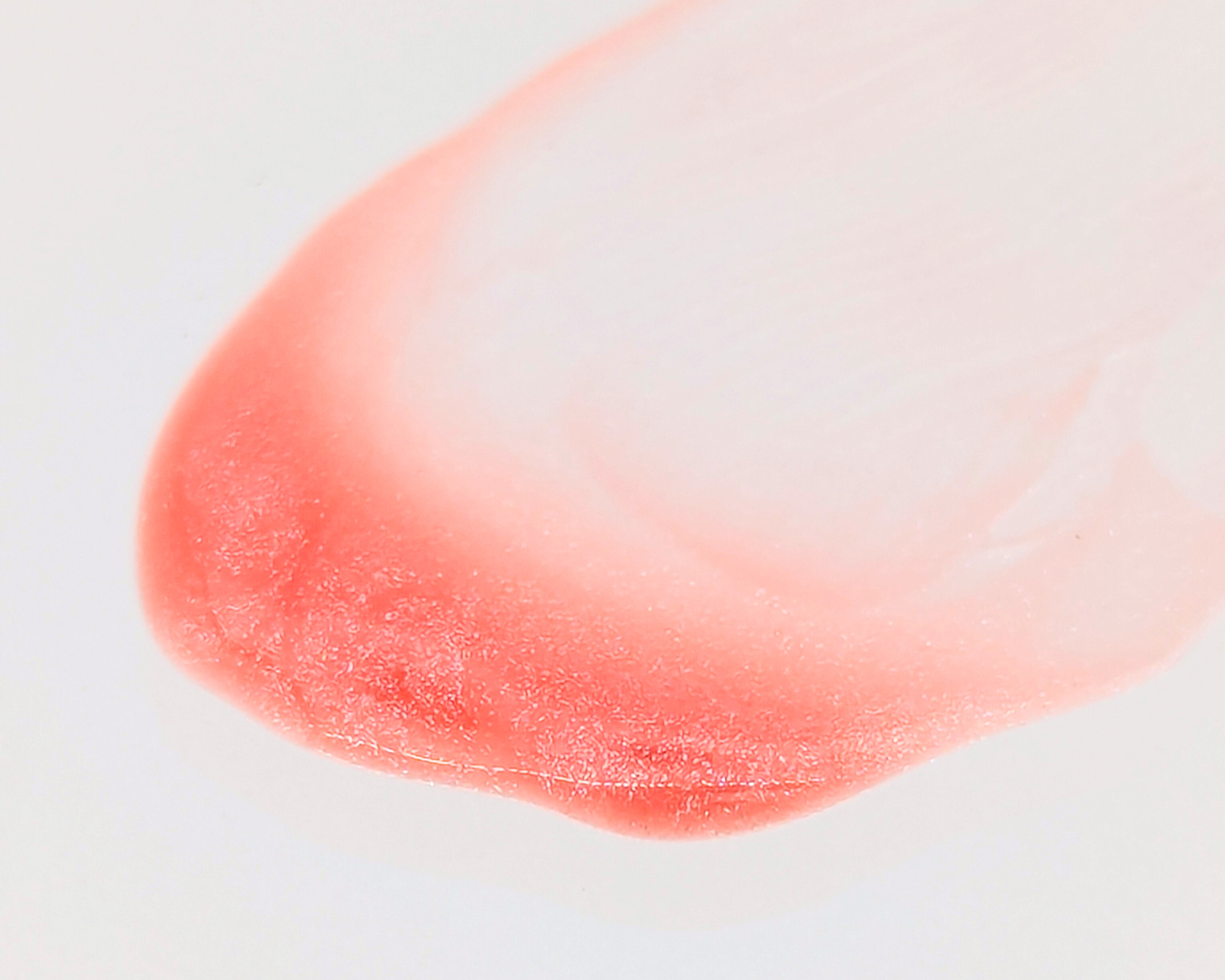 Covet Beauty’s Nude Pink lip gloss — a warm rosy-peach gloss with fine shimmer in a clear rectangular tube with black cap.