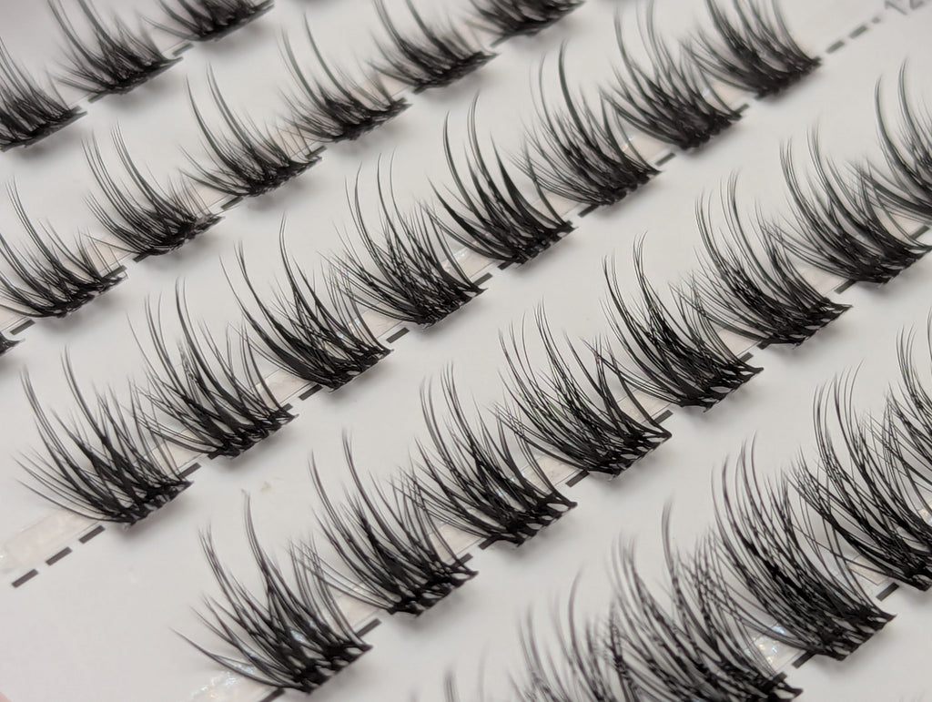 Covet Beauty Veil cluster lashes shown close-up in diagonal rows with soft, wispy fibers and a gentle curl.