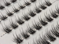 Covet Beauty Veil cluster lashes shown close-up in diagonal rows with soft, wispy fibers and a gentle curl.