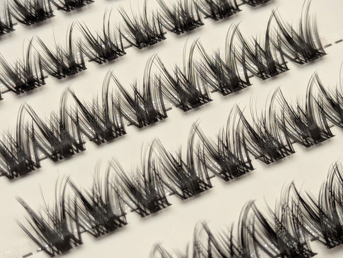 Covet Beauty Command cluster lashes shown close-up with lifted, separated lash clusters arranged in diagonal rows.