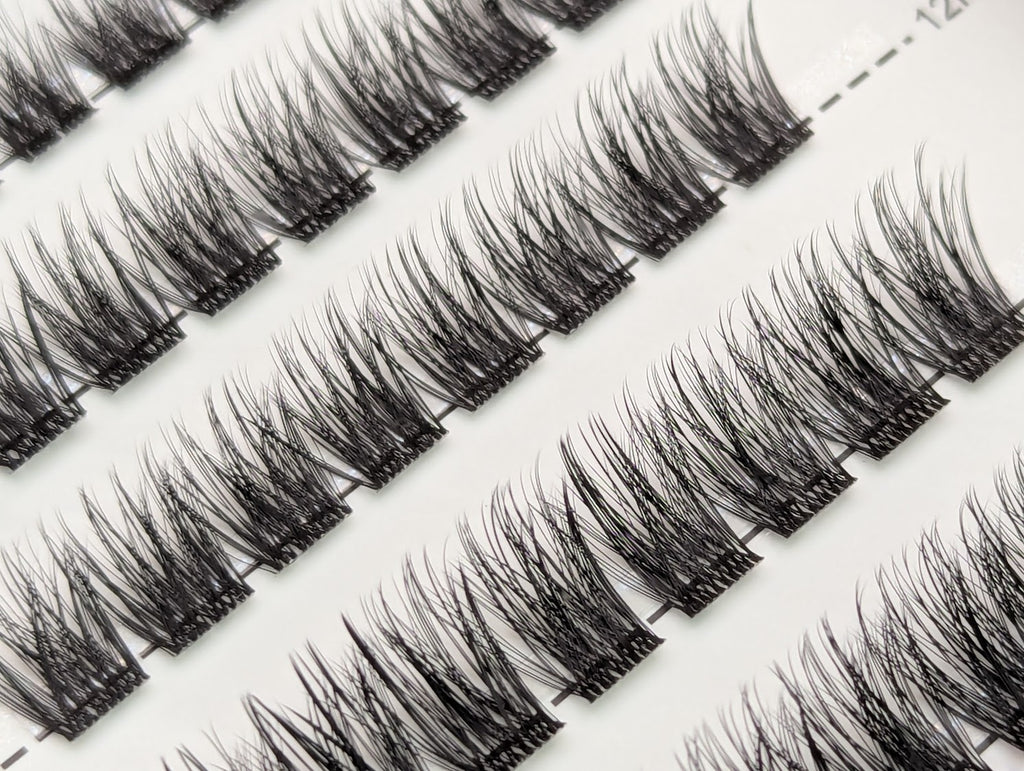 Close-up of Covet Beauty Trance cluster lashes showing soft, wispy fibers and a gentle curl in the tray.