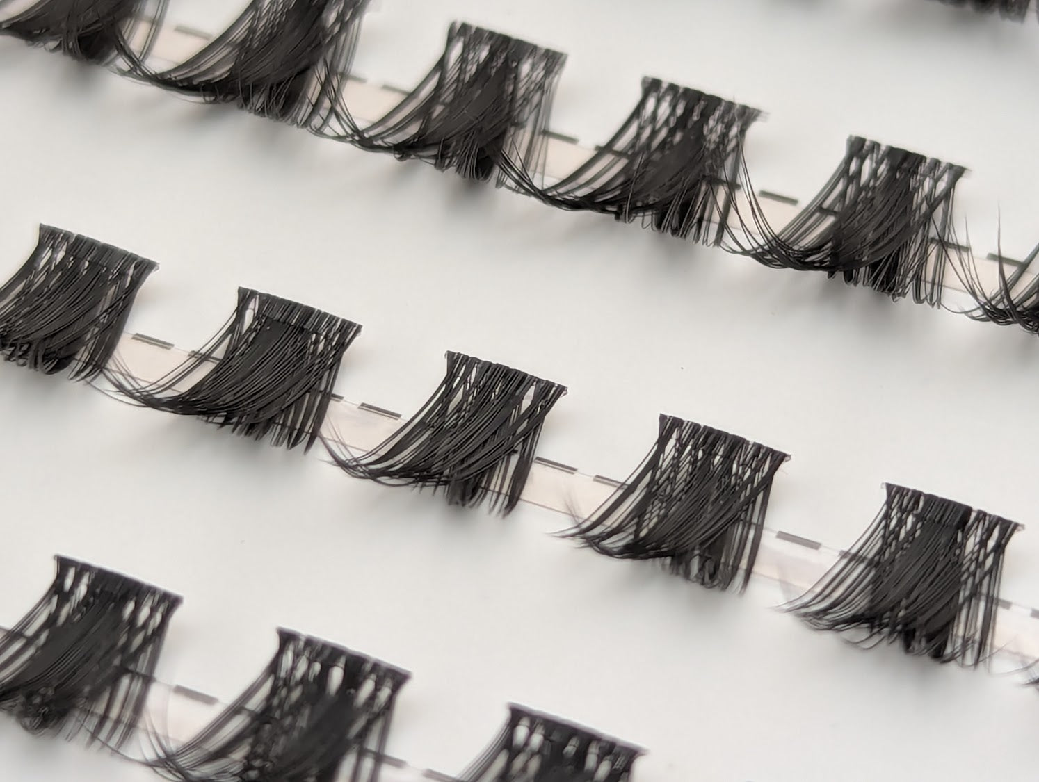 Covet Beauty Control cluster lashes shown close-up with lifted, curved lash clusters arranged in rows.