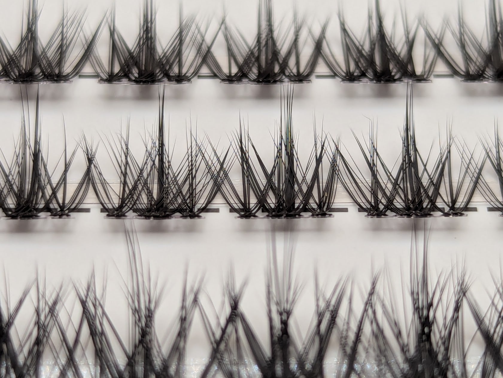 Covet Beauty Vision cluster lashes shown close-up with a soft, airy crisscross lash pattern in the tray.