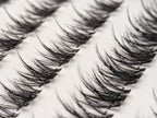 Covet Beauty Vision cluster lashes shown close-up with soft, airy fibers and a curved lash shape in the tray.