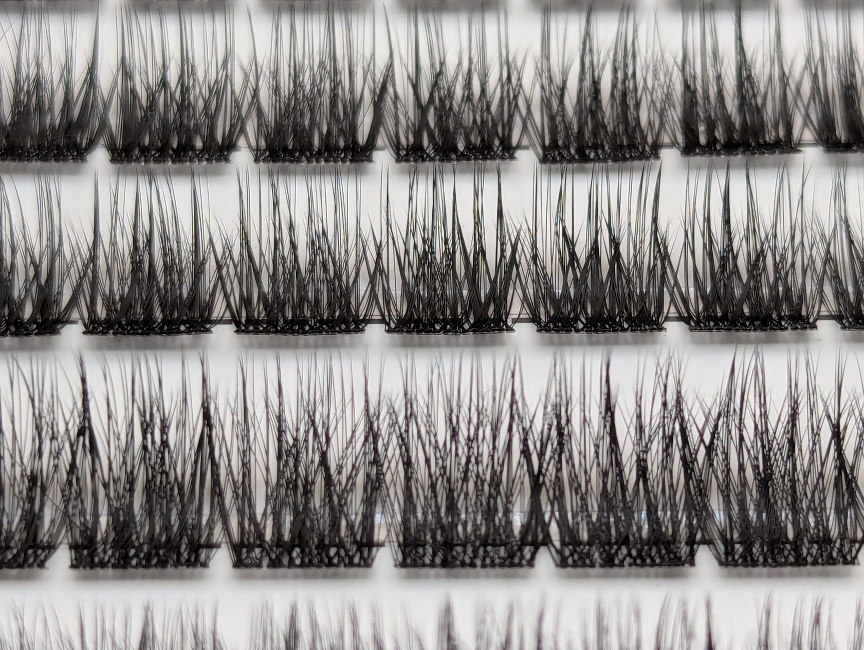 Covet Beauty Velvet cluster lashes shown close-up in the tray with rows of dense, defined crisscross lash fibers.