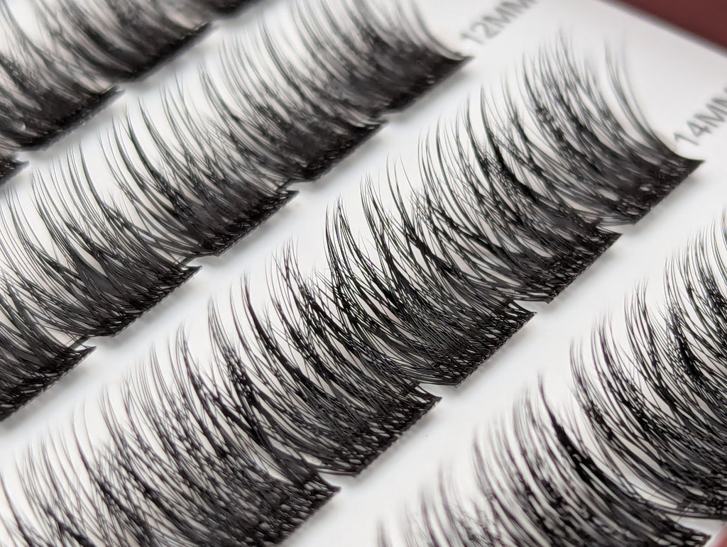 Covet Beauty Velvet cluster lashes shown close-up with dense, curled fibers and a defined lash pattern in the tray.