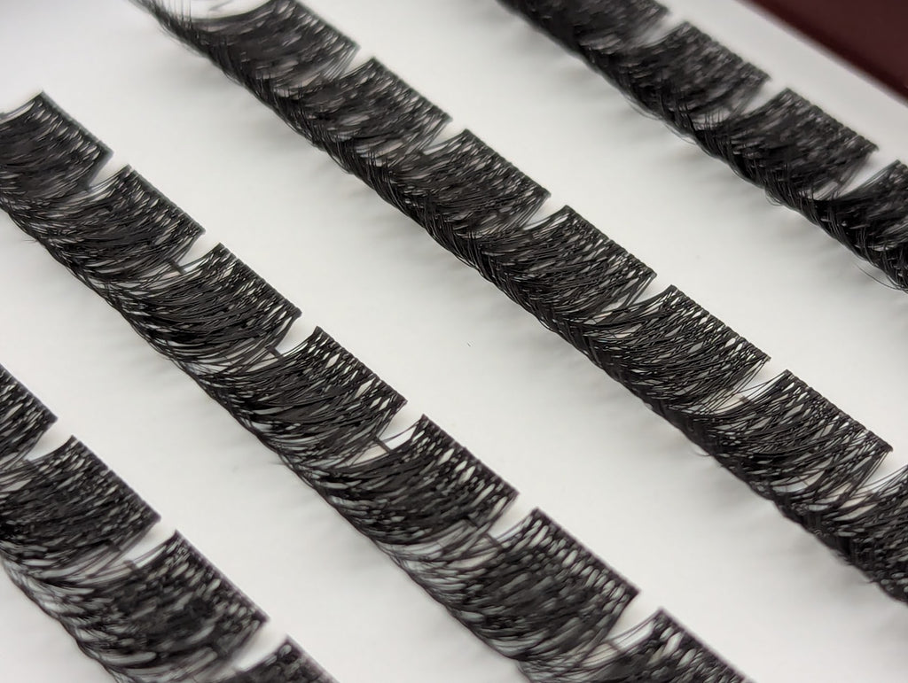 Covet Beauty Velvet cluster lashes shown close-up in diagonal rows with dense, curled fibers and a full lash pattern.