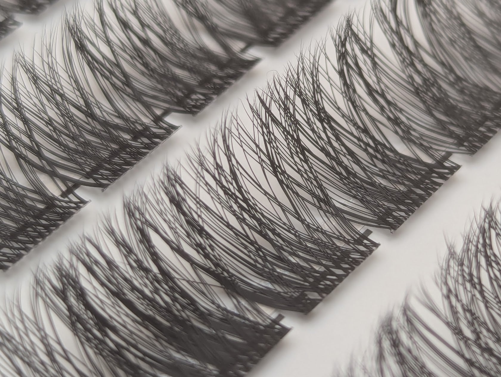 Close-up of Covet Beauty Hush cluster lashes showing a light, wispy lash pattern in the tray.