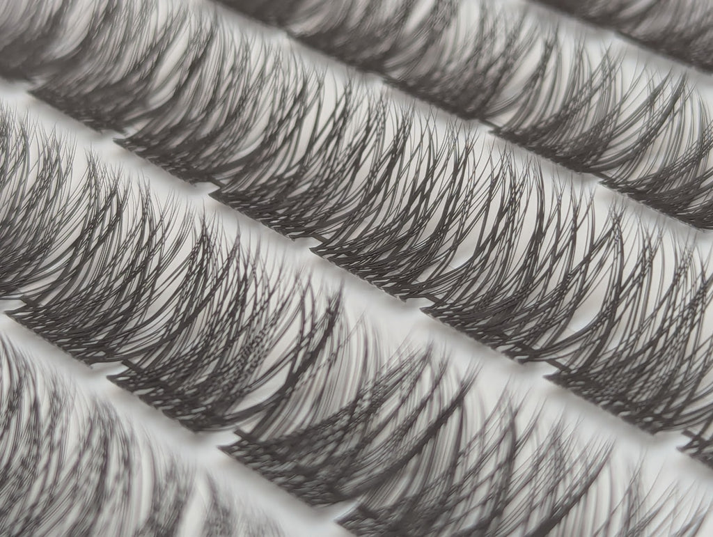 Covet Beauty Hush cluster lashes shown close-up with soft, wispy layered fibers in the tray.