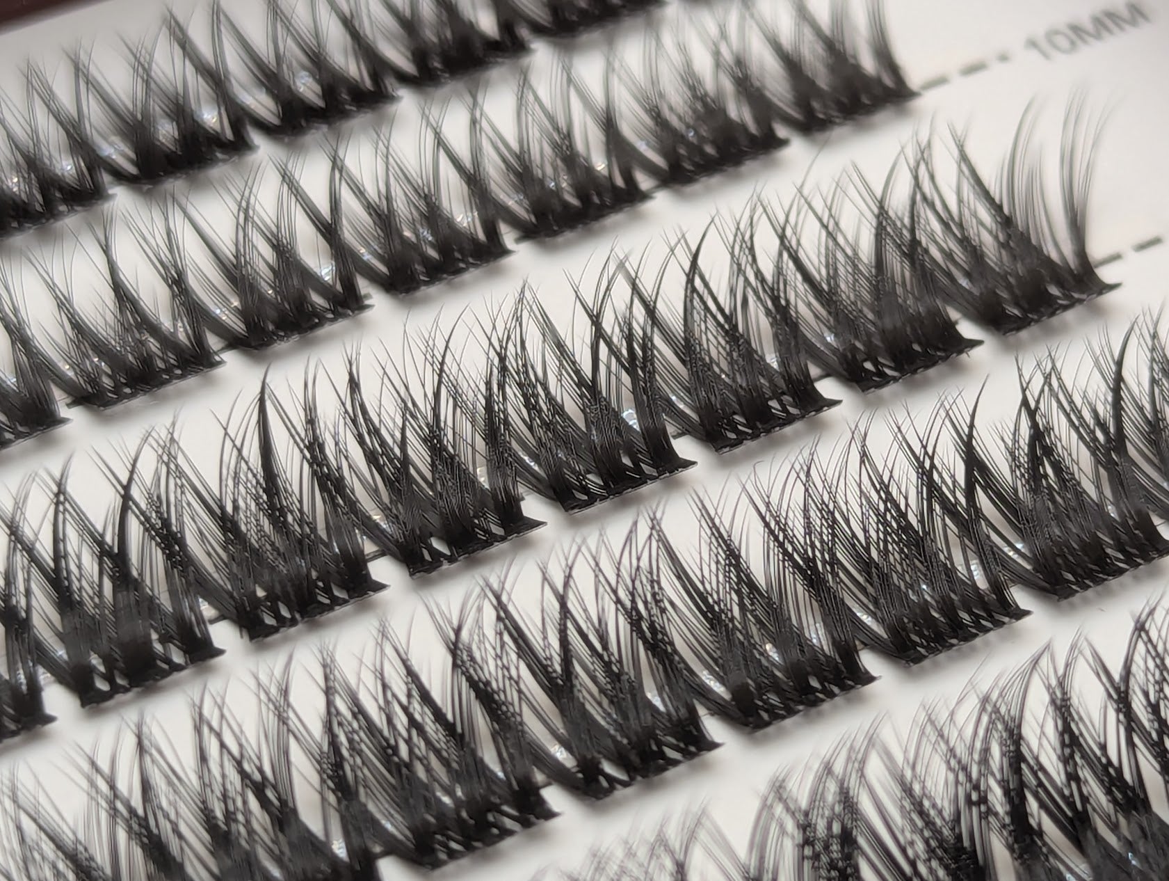 Close-up of Covet Beauty Obsession cluster lashes in the tray, showing rows of dense crisscross lash clusters.