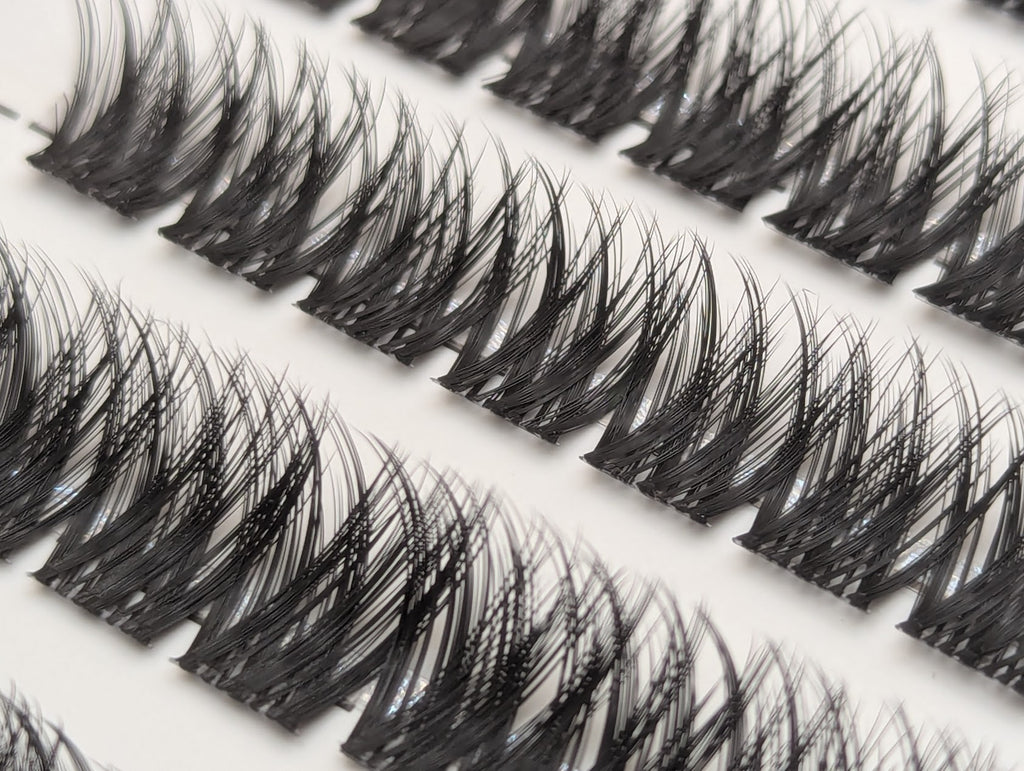 Close-up of Covet Beauty Obsession cluster lashes in the tray, showing rows of dense crisscross lash clusters.