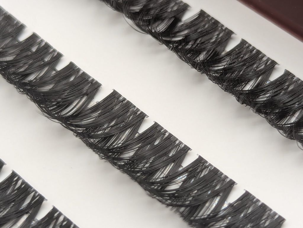 Covet Beauty Obsession cluster lashes in the tray, showing layered curl and dense crisscross fibers.