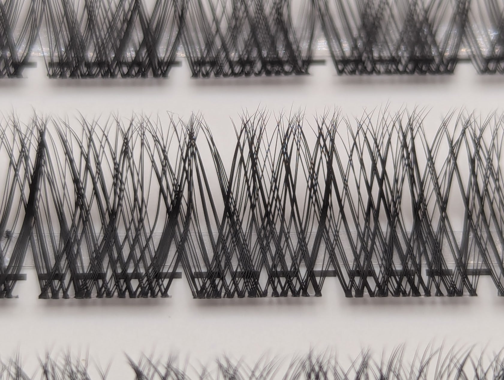 Close-up of Covet Beauty Hush cluster lashes showing a wispy crisscross lash pattern in the tray.