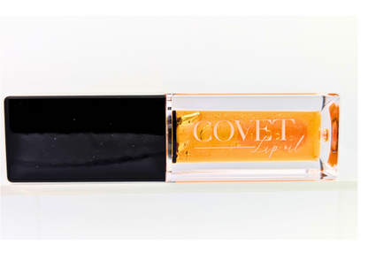 Covet Beauty’s Saturn lip gloss — a shimmering orange gloss in a clear rectangular tube with black cap. Transforms into a soft rose pink based on skin pH and heat.