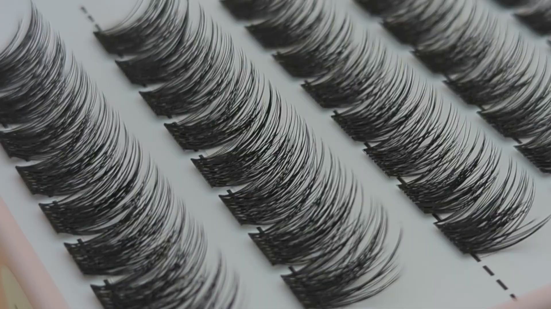 Covet Beauty Trance cluster lashes shown close-up in diagonal rows with soft, wispy curled fibers.